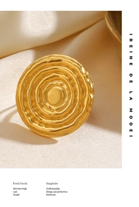 Macro view of golden geometric ring with concentric water ripple texture on satin fabric