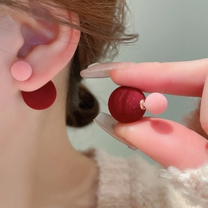 Macro detail of wine red and pink velvet double ball stud earrings with silver needles