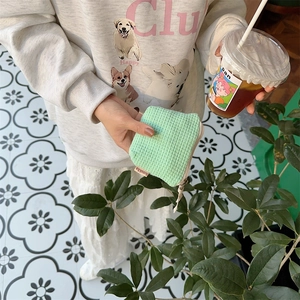 Gros plan sur la pochette gaufrée vert menthe pour le rangement quotidien du maquillage