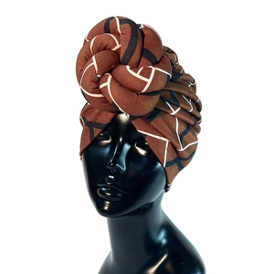 Detail of the brown geometric pattern and twisted knot design on suede turban