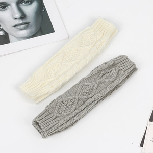 Detail of cable knit pattern on soft cream and grey arm warmers with diamond texture
