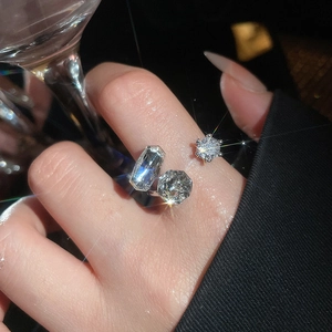 Close-up of geometric zircon ring featuring rectangular and cushion cut stones on silver band