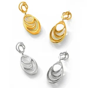 Detailed macro view of layered teardrop hoop earrings in gold and silver finish
