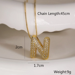 Detailed view of gold 'N' pendant necklace with clear zircon stones and size dimensions