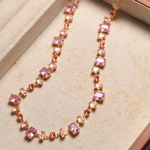 Close-up of pink oval crystal necklace with gold chain in a premium jewelry gift box