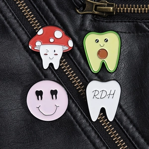 Close-up of colorful tooth enamel pins styled on a black leather jacket pocket