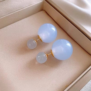 Detailed macro view of large marble blue and translucent grey double bead stud earrings