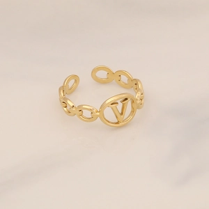 Gold chain-link stainless steel ring featuring a central V-logo over marble background