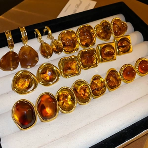 Vintage Maillard resin geometric earrings set with amber tones on black velvet