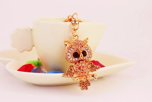 Detail of owl keychain with golden rhinestones and black faceted gemstone eyes