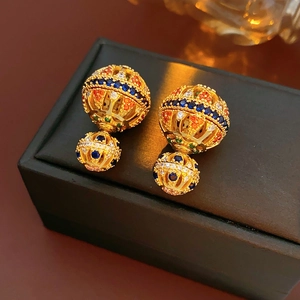 Gros plan détaillé de boucles d'oreilles vintage en plaqué or 18k avec gemmes multicolores