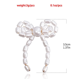 Detail of pearl bow earrings showing 3.5cm height and 3g weight with mirror reflection
