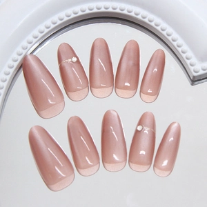 Elegant almond shape press-on nails with nude pink cat eye finish and pearl rhinestones
