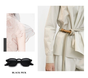 Detailed view of black round frame sunglasses with a stylish beige knotted belt accessory