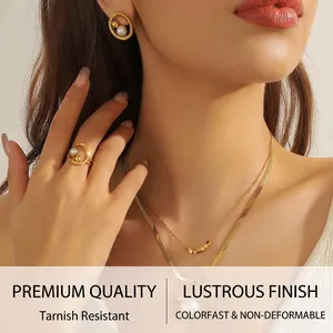 Elegant gold jewelry set with round pearl necklace, layered chains, ring and earrings