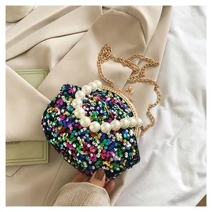 Detail of sequin mini shell bag with pearl handle and golden chain strap