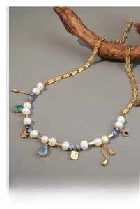 Detailed macro view of French vintage necklace with freshwater pearls and blue charms