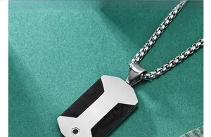 Dettaglio del ciondolo dog tag in argento con inserto in fibra di carbonio nera e catena