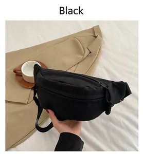 Detail of minimalist black nylon sling bag featuring high-quality zippers and woven pullers