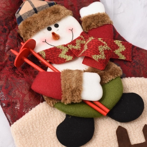 Close-up of a 3D snowman Christmas stocking with plaid hat and red glitter scarf detail