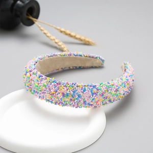 Close-up of colorful glitter bead headband with soft fabric lining on white stand