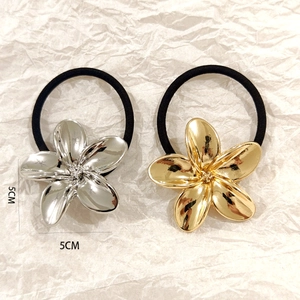 Close-up of 5cm hollow flower hair ties in gold and silver finish with black elastic bands