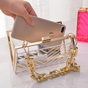 Transparent acrylic evening clutch bag with gold chain and V-pattern showing phone capacity
