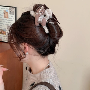 Detailed view of the brown plush pony hair claw clip worn on a woman's bun hairstyle