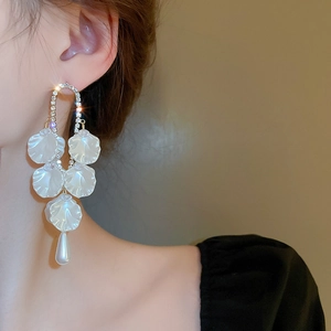 Détail de boucles d'oreilles fleurs avec cristaux et perles goutte sur mannequin