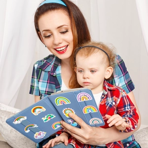 Close-up of mother and child decorating a tablet cover with colorful rainbow stickers