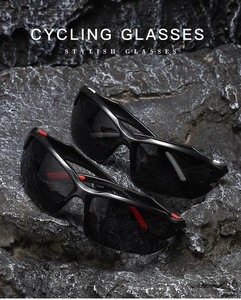 Macro view of two black cycling glasses with red accents on a rugged gray rock surface