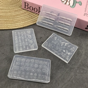 Four transparent silicone nail art molds with butterfly and key patterns on a textured surface