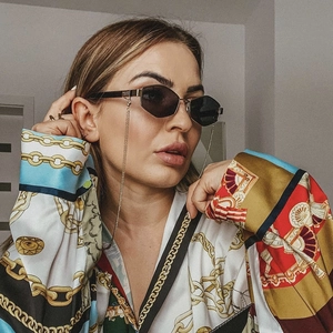 Women's black round sunglasses with gold chain accessory and geometric metal frame
