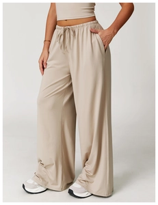 Detail of loose wide leg trousers featuring an elastic drawstring waist and side pockets