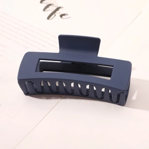 Detailed close-up of dark blue matte large hair claw clip with rectangular hollow structure