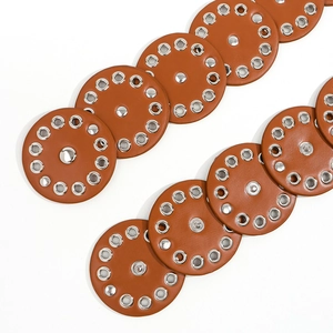 Close-up of brown leather disc waist belt with silver metal rivets and grommets