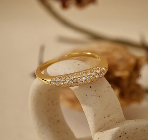 Macro view of gold plated adjustable open ring with sparkling pavé cubic zirconia setting