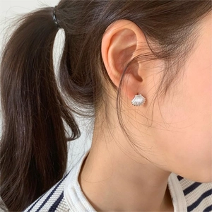 Close-up of minimalist 925 silver shell stud earring worn on a model's ear lobe