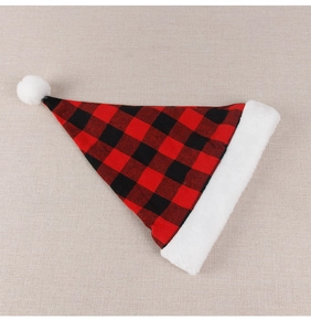 Detail of red and black buffalo plaid Christmas hat with white plush trim and pom-pom