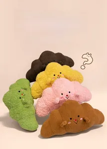 Close-up of colorful croissant plush pillows in soft sherpa fabric with cute faces