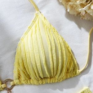 Detail of yellow bikini top featuring pleated texture and rhinestone gold O-ring buckle