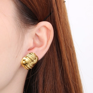 Close-up of elegant gold irregular wrinkled texture stud earrings on model's ear