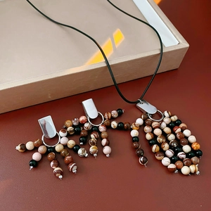 Close-up of vintage beaded necklace set with natural stone fringe and silver hardware
