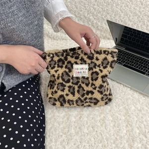 Macro view of plush leopard print makeup bag with a soft texture and brand label