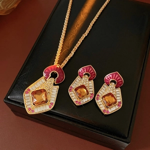 Macro shot of vintage gold jewelry set with red enamel and amber stones in a gift box