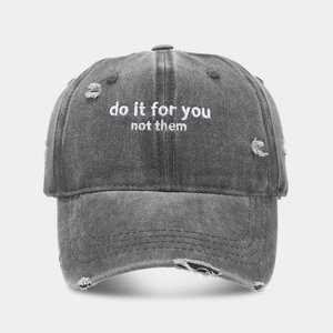 Close-up of vintage washed cotton baseball cap with distressed holes and embroidery