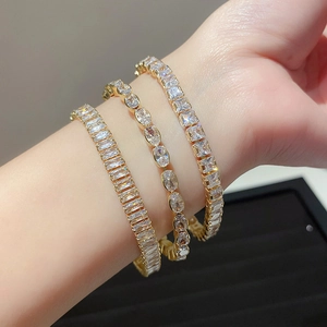 Gold tennis bracelet set featuring rectangular, oval and square cut cubic zirconia stones