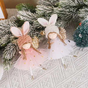 Plush Christmas angel tree toppers with lace skirts and golden wings on snowy pine branches