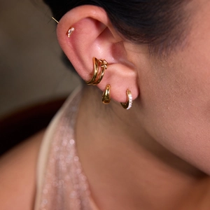 Vue macro d'un set de boucles d'oreilles étoile dorées et créoles avec diamants