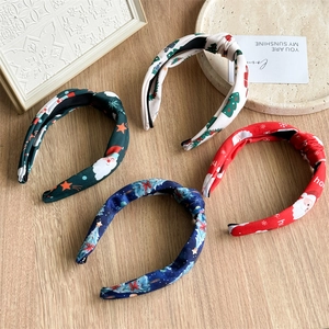 Flat lay view of four festive Christmas knot headbands with Santa Claus and tree patterns